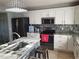 Updated kitchen with stainless steel appliances, white cabinets, and granite countertops and a large island at 907 Gloucester Ct, Kissimmee, FL 34758