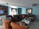 Living room featuring blue walls, tile floors and a comfortable brown sectional sofa at 907 Gloucester Ct, Kissimmee, FL 34758