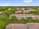 An aerial view displays residential buildings with green lawns and trees on a bright, sunny day at 1225 Coral Coast Dr, Orlando, FL 32824