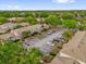 A neighborhood aerial view showing parking, beige exteriors, green spaces and mature trees on a sunny day at 1225 Coral Coast Dr, Orlando, FL 32824