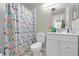 Bathroom with a shower, decorative shower curtain, white vanity, and neutral-tone tile flooring at 1225 Coral Coast Dr, Orlando, FL 32824