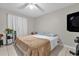 Well-lit bedroom with tile flooring, ceiling fan, and a comfortable bed with a light brown blanket at 1225 Coral Coast Dr, Orlando, FL 32824