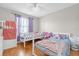 Bright bedroom with two toddler beds, a window with purple curtains, and wood-look flooring at 1225 Coral Coast Dr, Orlando, FL 32824