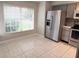 Bright breakfast nook features tile floors, window, and a stainless steel refrigerator at 1225 Coral Coast Dr, Orlando, FL 32824