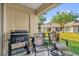 A cozy outdoor patio featuring a grill, patio furniture, a door, and a view of the grassy yard at 1225 Coral Coast Dr, Orlando, FL 32824