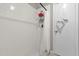 Tiled shower with white shower curtain, a rack for shower products, and a hook for a towel at 1225 Coral Coast Dr, Orlando, FL 32824