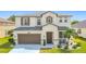 Charming two-story home featuring a well-manicured lawn, two-car garage and a welcoming front porch at 178 Forest View Dr, Davenport, FL 33896