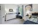 Well-lit bedroom with a white dresser, desk, and a painting of a seashell on the wall at 3704 Via Monte Napoleone Dr, Poinciana, FL 34759