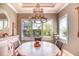 Dining room with a chandelier, white shutters, and a round table set for four at 3704 Via Monte Napoleone Dr, Poinciana, FL 34759