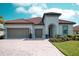 Beautiful home featuring a brick driveway, two-car garage, and meticulously maintained landscaping at 3704 Via Monte Napoleone Dr, Poinciana, FL 34759