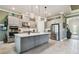 Spacious kitchen with a center island, gray cabinets, stainless steel appliances and pendant lighting at 3704 Via Monte Napoleone Dr, Poinciana, FL 34759