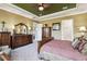Comfortable main bedroom with ensuite bathroom featuring a trey ceiling and fan at 3704 Via Monte Napoleone Dr, Poinciana, FL 34759