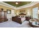 Elegant bedroom features a tray ceiling, a ceiling fan, an upholstered chair and natural light at 3704 Via Monte Napoleone Dr, Poinciana, FL 34759
