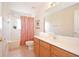 Bathroom with a single sink vanity, a framed mirror, and a shower with a red curtain at 423 Corvina Dr, Davenport, FL 33897