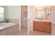 Bathroom with wood cabinets, tile floors, toilet room, and soaking tub at 423 Corvina Dr, Davenport, FL 33897