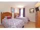 Bright bedroom featuring two beds with purple accents and a view of the neighborhood at 423 Corvina Dr, Davenport, FL 33897