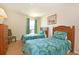 Bedroom showcasing twin beds with leaf patterned bedding, carpet flooring, and a wooden dresser at 423 Corvina Dr, Davenport, FL 33897