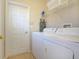 Well lit laundry room with washer, dryer, ironing board and storage space above at 423 Corvina Dr, Davenport, FL 33897