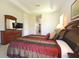 Comfortable main bedroom featuring tray ceiling, warm colors, and a wooden dresser with attached mirror at 423 Corvina Dr, Davenport, FL 33897