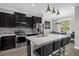 Modern kitchen with dark cabinets, stainless steel appliances, and a quartz countertop island at 1031 Wood Cv, Kissimmee, FL 34743