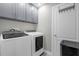 This laundry room features a modern washer and dryer plus plenty of cabinet space for storage at 1031 Wood Cv, Kissimmee, FL 34743