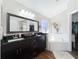 Luxurious bathroom with double sinks, a large mirror, a soaking tub, and access to a walk-in closet at 1102 Solana Cir, Davenport, FL 33897