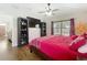 Bedroom featuring wood floors, dark furniture, a ceiling fan, and a large bed with red bedding at 1102 Solana Cir, Davenport, FL 33897
