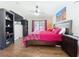 Bedroom with wood floors, dark furniture, a ceiling fan, and a large bed with red patterned bedding at 1102 Solana Cir, Davenport, FL 33897