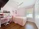 Charming bedroom with pink decor, a ceiling fan, natural light, and built-in shelving, perfect for a room at 1102 Solana Cir, Davenport, FL 33897