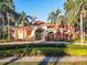 Attractive clubhouse entrance surrounded by lush landscaping and palm trees at 1102 Solana Cir, Davenport, FL 33897