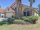 Beautiful single-story home with a terra cotta roof, two-car garage, lush landscaping and mature palm trees at 1102 Solana Cir, Davenport, FL 33897