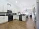 Modern kitchen with white cabinets, black countertops, stainless steel appliances, and wood flooring at 1102 Solana Cir, Davenport, FL 33897