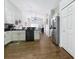 Open kitchen with wood floors, white cabinets, stainless steel appliances, and seamless flow to the dining and living areas at 1102 Solana Cir, Davenport, FL 33897