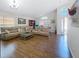 Bright, open-concept living room featuring wood floors, comfortable sofas, and ample natural light at 1102 Solana Cir, Davenport, FL 33897
