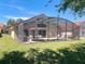 Backyard screened-in pool featuring an outdoor seating area and lush landscaping at 1102 Solana Cir, Davenport, FL 33897