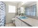 Well lit bathroom featuring a unique blue sink, tile flooring, and a matching striped shower curtain at 1204 Pleasant Pl, Lakeland, FL 33801