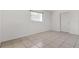 The bedroom offers tile flooring, neutral walls, and natural light from the front window at 1204 Pleasant Pl, Lakeland, FL 33801