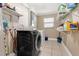 Spacious laundry room features modern washer and dryer, tile flooring, and ample shelving at 1204 Pleasant Pl, Lakeland, FL 33801