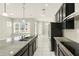 Bright kitchen features granite countertops, stainless appliances and black cabinets at 1370 Kiawah St, Celebration, FL 34747