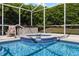 Relaxing hot tub adjacent to a screened pool, surrounded by lush landscaping and a lounge chair at 1821 N Hampton Dr, Davenport, FL 33897
