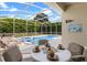 Enclosed pool and patio, including an outdoor dining area surrounded by privacy hedges at 1821 N Hampton Dr, Davenport, FL 33897