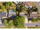 This aerial view shows a home in a neighborhood with a nearby pool, mature trees, and a well-maintained lawn at 201 La Paz Dr, Kissimmee, FL 34743