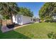 Charming backyard with a lush lawn, privacy fence, brick walkway and white house elevation at 201 La Paz Dr, Kissimmee, FL 34743