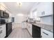 Bright kitchen featuring white cabinets, granite countertops, and modern black appliances at 201 La Paz Dr, Kissimmee, FL 34743