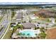 Aerial view of a pool and clubhouse, nestled among homes and greenery, ideal for community gatherings at 2705 Grandbury Grove Rd, Lakeland, FL 33811