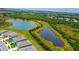Aerial of homes located next to a pond offering views of the lake and surrounding trees at 2705 Grandbury Grove Rd, Lakeland, FL 33811