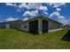 The backyard has a screened patio overlooking a lush green lawn and blue sky at 2705 Grandbury Grove Rd, Lakeland, FL 33811