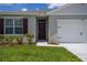 Close-up of a home's front entrance, showcasing a paneled door, manicured landscaping, and a two-car garage at 2705 Grandbury Grove Rd, Lakeland, FL 33811