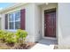 Close-up of a beautiful paneled front door, adjacent window with decorative shutters, and landscaped entryway at 2705 Grandbury Grove Rd, Lakeland, FL 33811