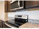Close-up of kitchen featuring granite countertops, stainless steel appliances, and dark wood cabinetry at 2705 Grandbury Grove Rd, Lakeland, FL 33811